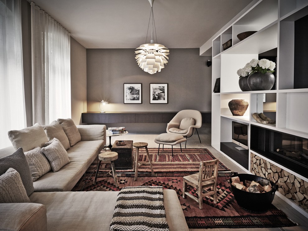 Cette image montre une salle de séjour design fermée avec un mur gris, parquet foncé, une cheminée double-face et un manteau de cheminée en plâtre.