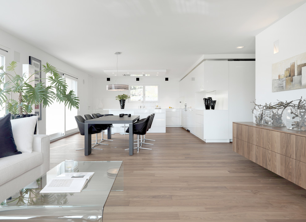 Offenes, Mittelgroßes Modernes Wohnzimmer ohne Kamin mit weißer Wandfarbe und braunem Holzboden in Stuttgart