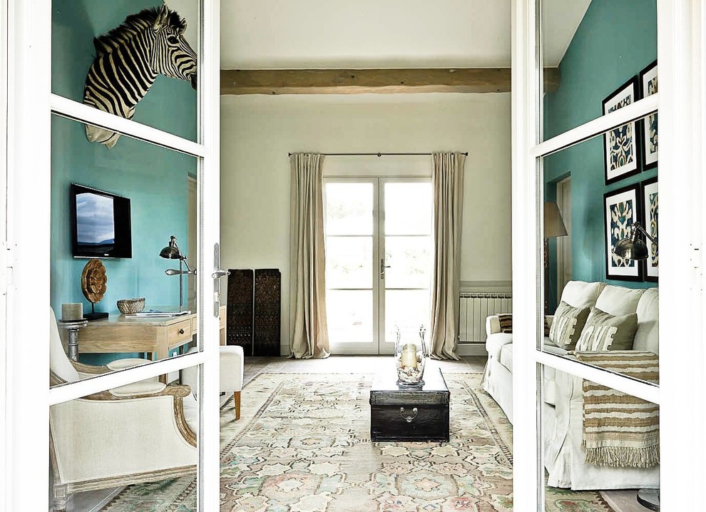 Стильный дизайн: изолированная гостиная комната среднего размера в средиземноморском стиле с синими стенами, ковровым покрытием и телевизором на стене - последний тренд