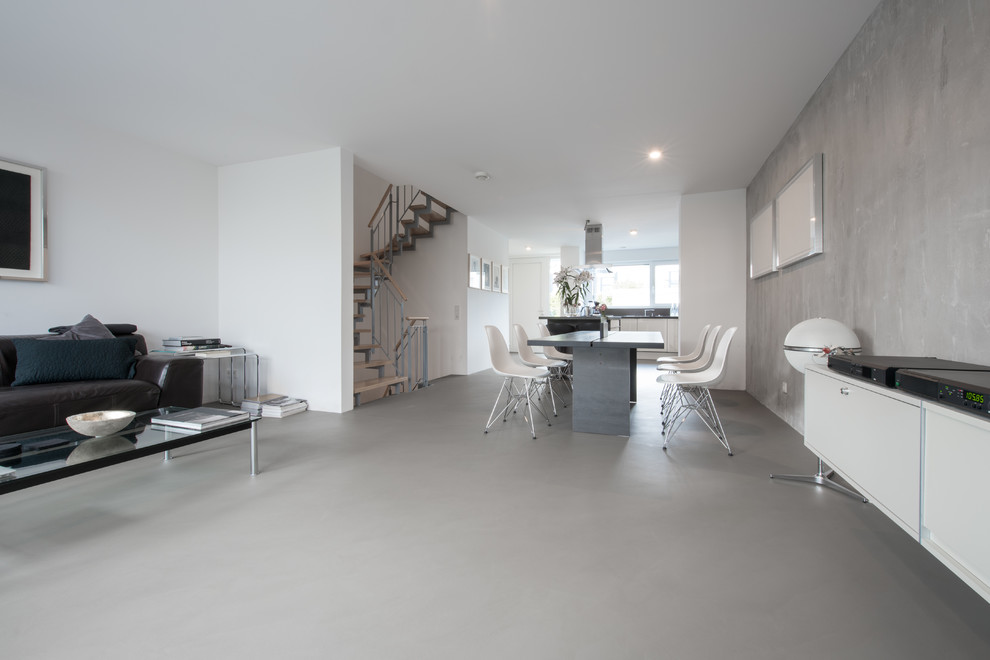 Immagine di un ampio soggiorno industriale aperto con pavimento in cemento, pavimento grigio, sala formale e pareti grigie