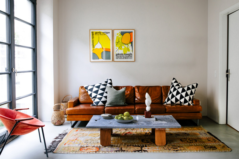 Fernseherloses, Offenes Modernes Wohnzimmer ohne Kamin mit beiger Wandfarbe und grauem Boden in Berlin
