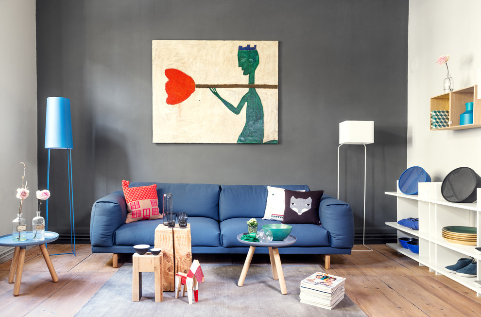 Foto de sala de estar actual sin chimenea y televisor con suelo de madera en tonos medios y paredes multicolor