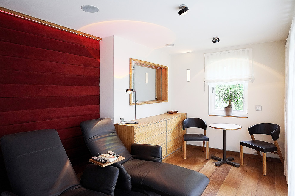 Kleines, Fernseherloses, Abgetrenntes Modernes Wohnzimmer ohne Kamin mit weißer Wandfarbe, braunem Holzboden und braunem Boden in Berlin