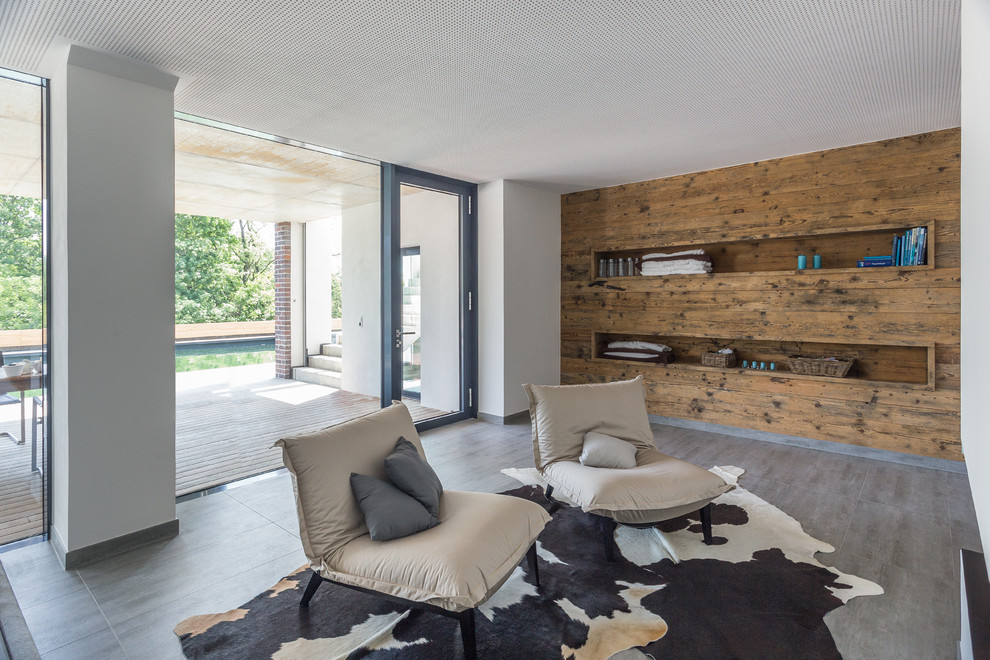 Modernes Wohnzimmer ohne Kamin mit weißer Wandfarbe, braunem Holzboden und braunem Boden in Sonstige