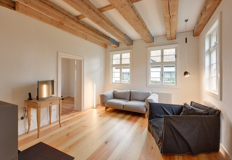 Mittelgroßes, Abgetrenntes Klassisches Wohnzimmer ohne Kamin mit weißer Wandfarbe, braunem Holzboden und freistehendem TV in Berlin
