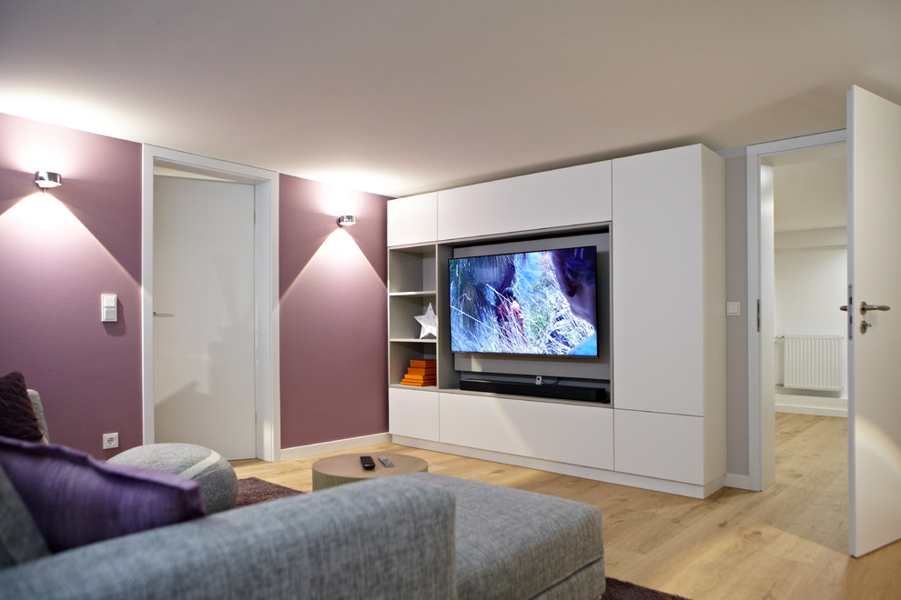 Réalisation d'une salle de séjour design avec un mur gris, parquet clair, un téléviseur fixé au mur et un sol beige.