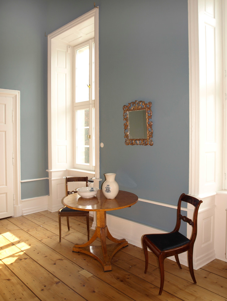 Ejemplo de salón cerrado actual grande sin chimenea y televisor con paredes azules, suelo de madera clara y suelo marrón