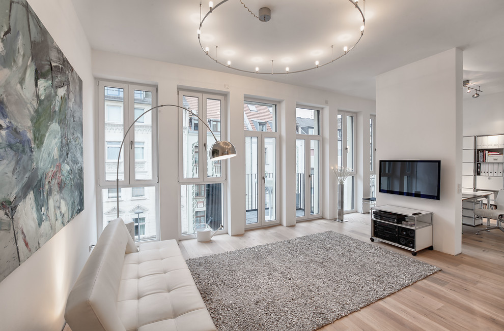 Foto di un grande soggiorno scandinavo aperto con sala formale, pareti bianche, parquet chiaro, nessun camino, TV a parete e pavimento beige