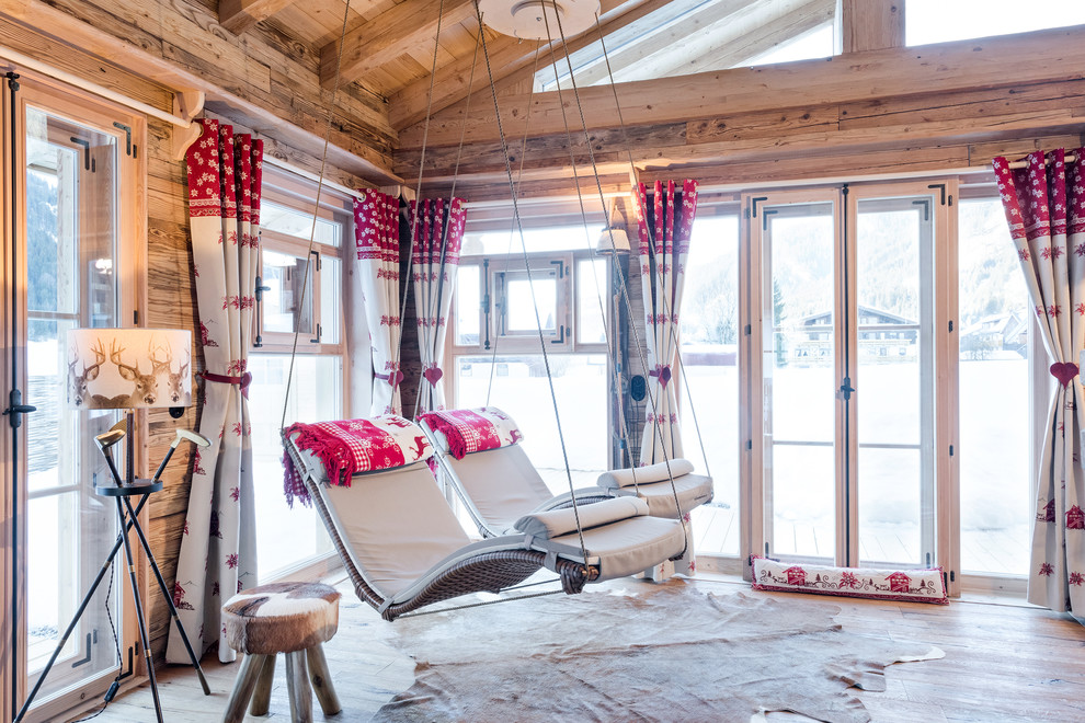 Exemple d'un salon montagne de taille moyenne avec un sol en bois brun, aucune cheminée et un mur marron.