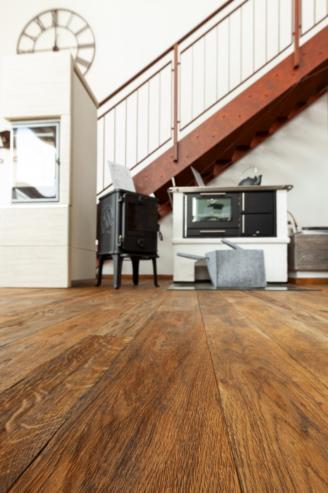 Rustikales Wohnzimmer mit braunem Holzboden und Kaminofen in München