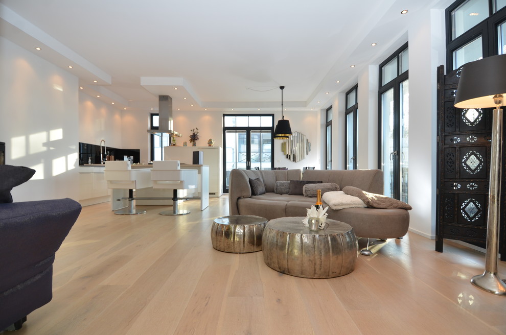 Imagen de salón para visitas actual extra grande sin chimenea con paredes blancas y suelo de madera clara