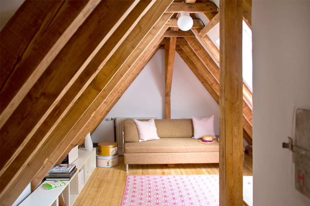 Abgetrenntes Nordisches Wohnzimmer mit weißer Wandfarbe und hellem Holzboden in Sonstige