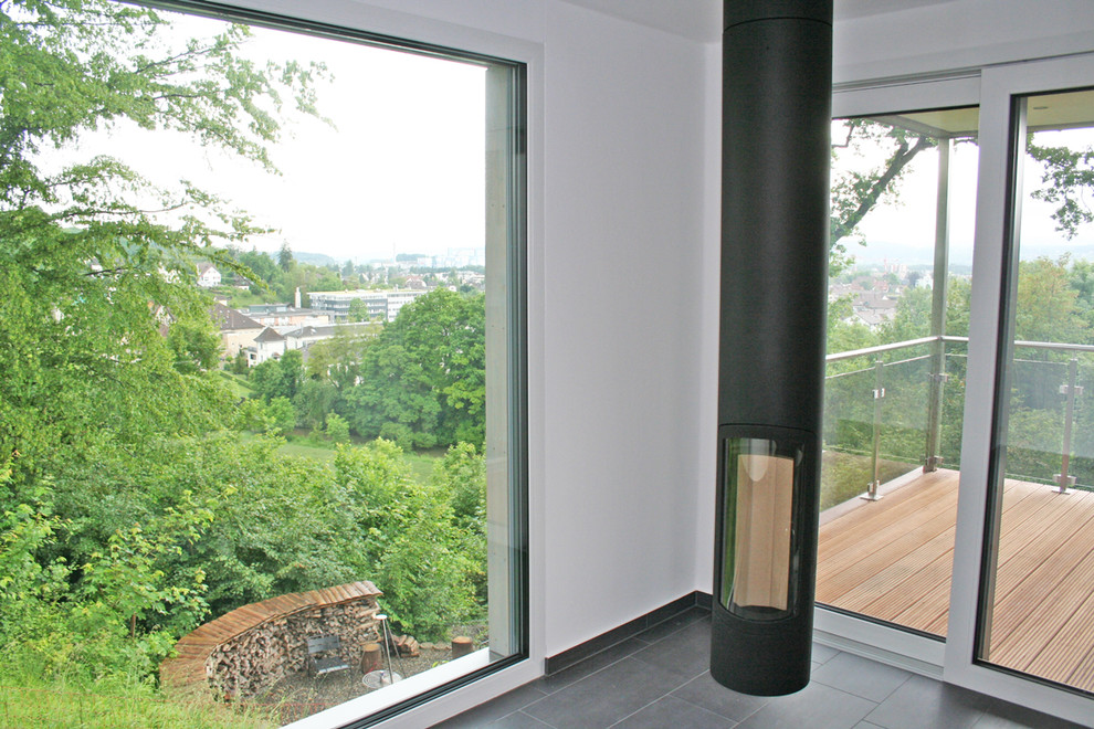 Immagine di un soggiorno minimalista di medie dimensioni con camino sospeso