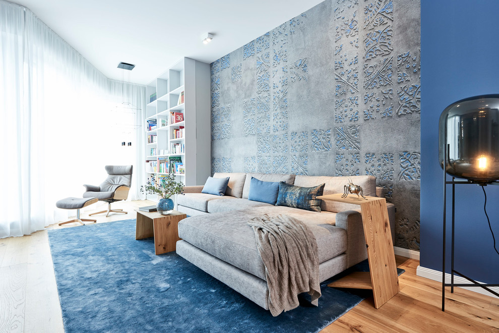 Mittelgroße Moderne Bibliothek mit blauer Wandfarbe, braunem Holzboden und braunem Boden in Hamburg