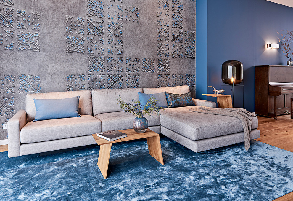 Ispirazione per un grande soggiorno minimal chiuso con pareti blu, pavimento in legno massello medio, TV a parete e pavimento marrone