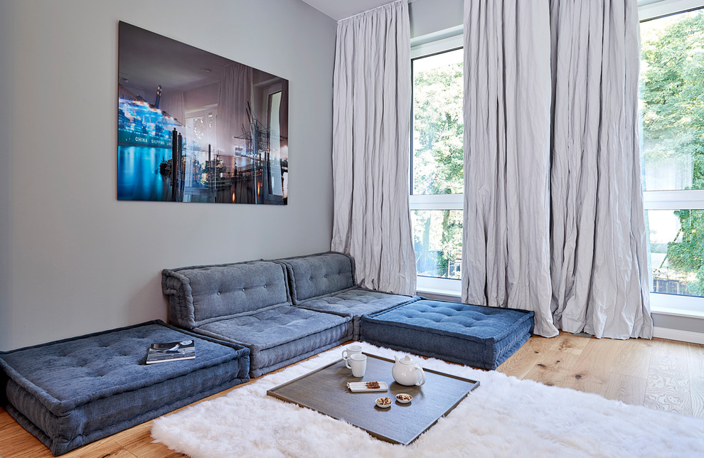 Mittelgroßes, Abgetrenntes, Repräsentatives, Fernseherloses Modernes Wohnzimmer ohne Kamin mit grauer Wandfarbe, braunem Holzboden und braunem Boden in Hamburg