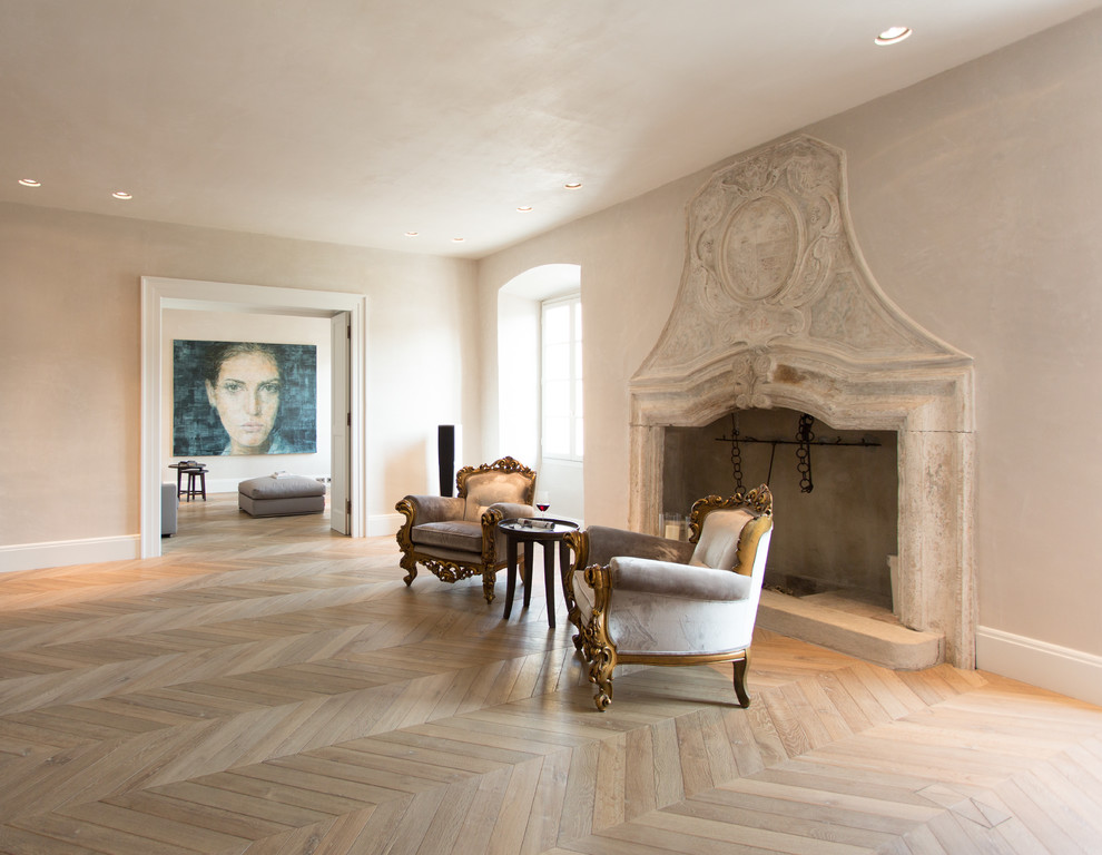 Immagine di un grande soggiorno design aperto con sala formale, pareti beige, pavimento in legno massello medio, camino classico e cornice del camino in pietra