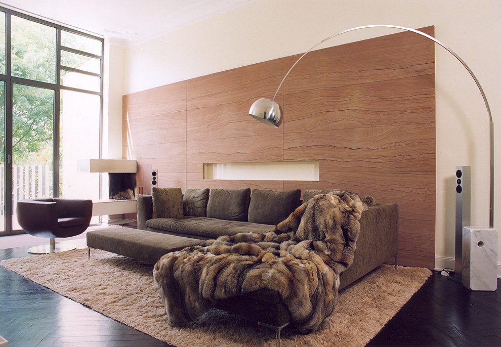 Идея дизайна: большая гостиная комната в современном стиле с бежевыми стенами, темным паркетным полом, двусторонним камином и коричневым диваном