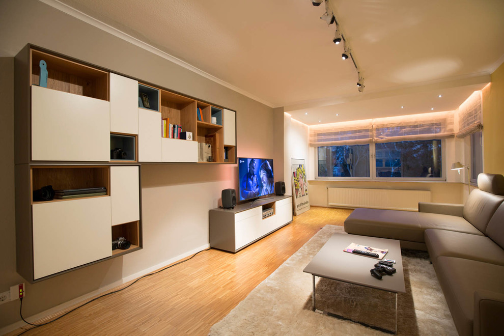 Großes, Offenes Modernes Wohnzimmer mit hellem Holzboden, freistehendem TV und bunten Wänden in Frankfurt am Main