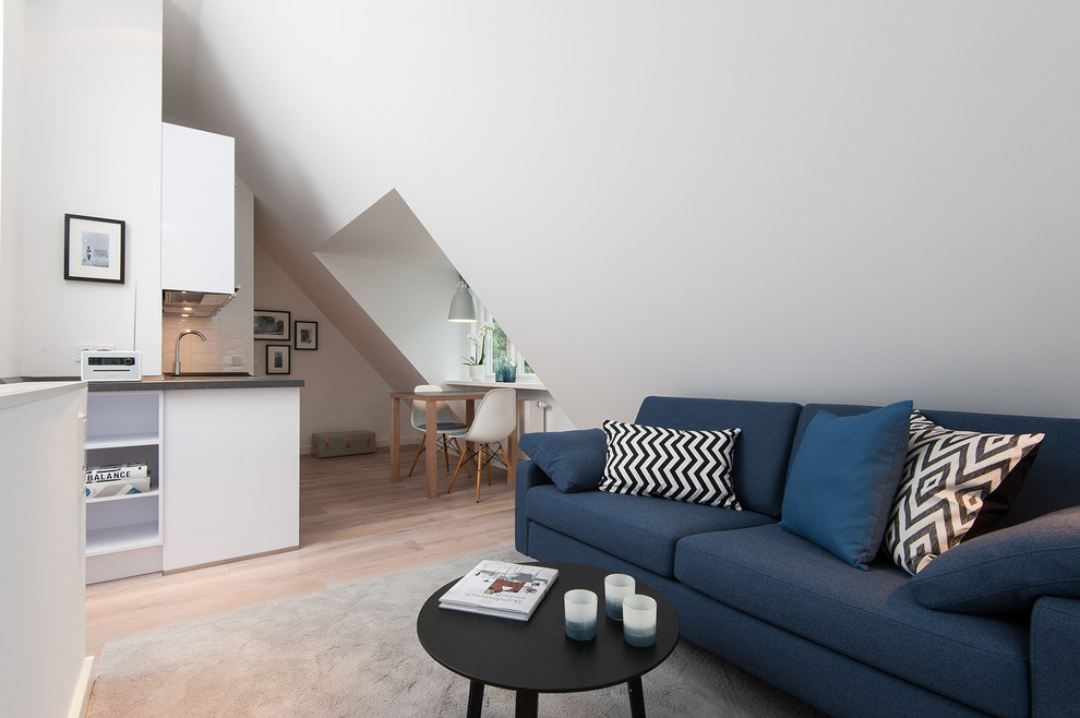 Immagine di un piccolo soggiorno nordico con pareti bianche, pavimento in legno massello medio, nessun camino e nessuna TV