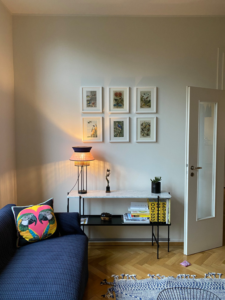Идея дизайна: гостиная комната в стиле фьюжн с белыми стенами и светлым паркетным полом