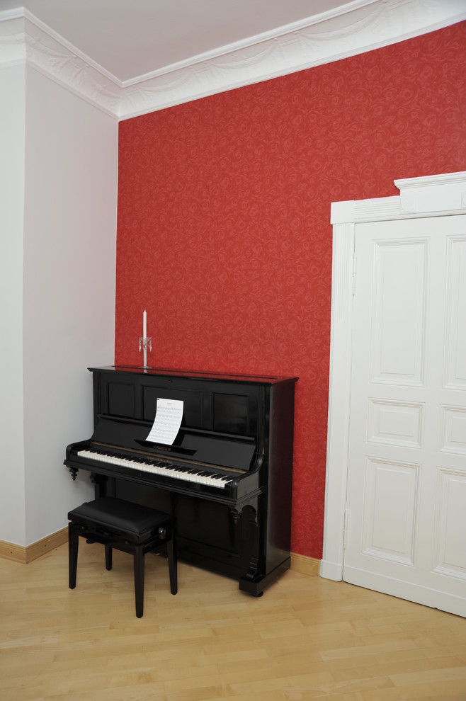 На фото: гостиная комната в современном стиле с музыкальной комнатой, светлым паркетным полом и красными стенами