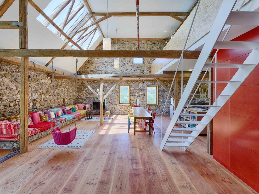 Example of a large eclectic formal and open concept medium tone wood floor and beige floor living room design in Other with gray walls and a tv stand