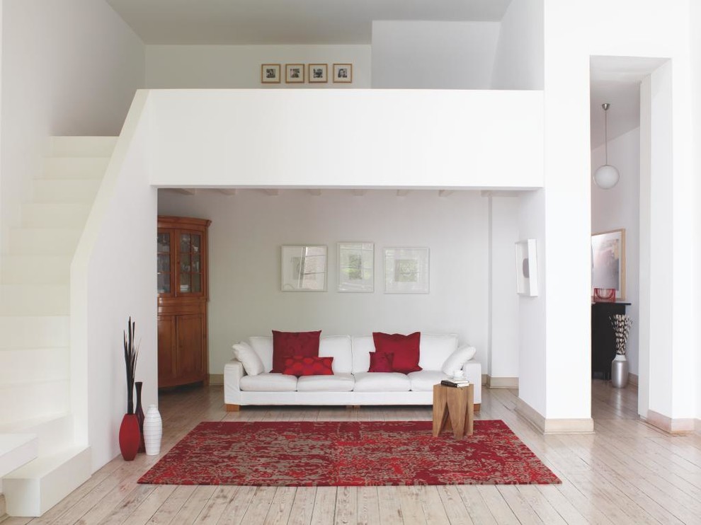 Kleines, Offenes, Fernseherloses Modernes Wohnzimmer ohne Kamin mit weißer Wandfarbe und gebeiztem Holzboden in Sonstige