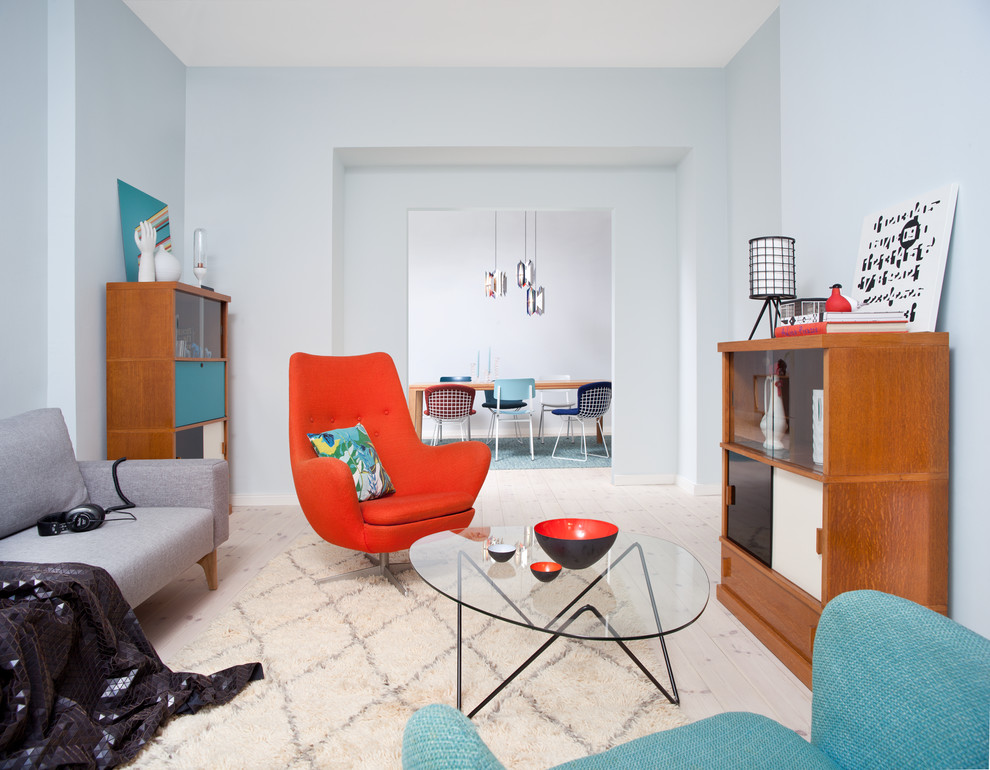 Repräsentatives, Mittelgroßes, Fernseherloses, Abgetrenntes Retro Wohnzimmer ohne Kamin mit blauer Wandfarbe und hellem Holzboden in Berlin