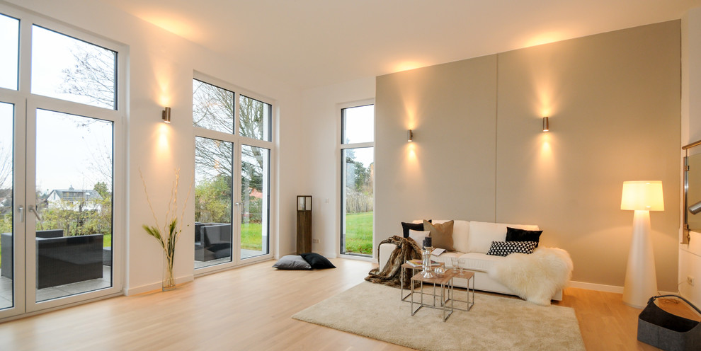Großes, Abgetrenntes Modernes Wohnzimmer mit beiger Wandfarbe und hellem Holzboden in Sonstige