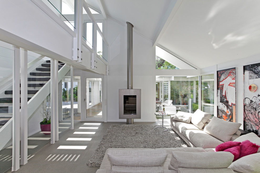 Immagine di un grande soggiorno design stile loft con pareti bianche, pavimento con piastrelle in ceramica, stufa a legna, nessuna TV e pavimento grigio