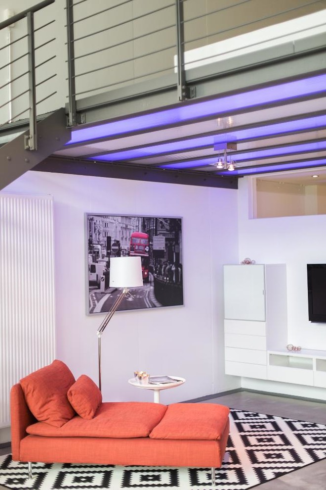 Idéer för mellanstora industriella allrum på loftet, med vita väggar, betonggolv, en väggmonterad TV och grått golv