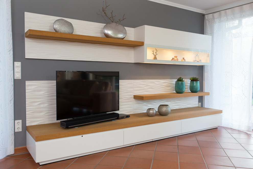 На фото: большая гостиная комната в современном стиле с серыми стенами, полом из терракотовой плитки и отдельно стоящим телевизором