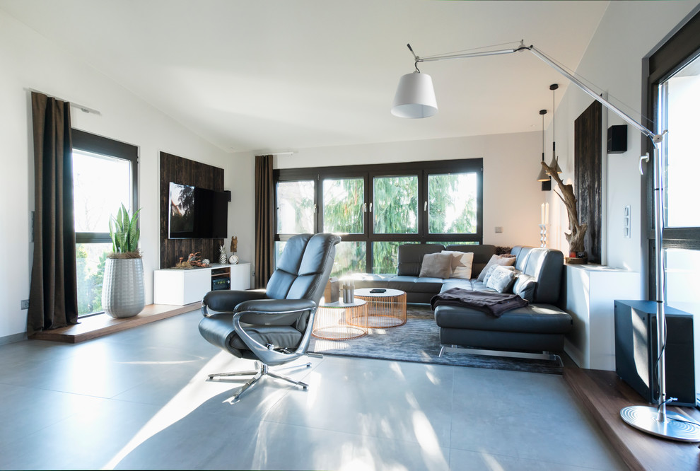 Großes, Repräsentatives, Offenes Modernes Wohnzimmer mit weißer Wandfarbe, Betonboden, TV-Wand und grauem Boden in Nürnberg