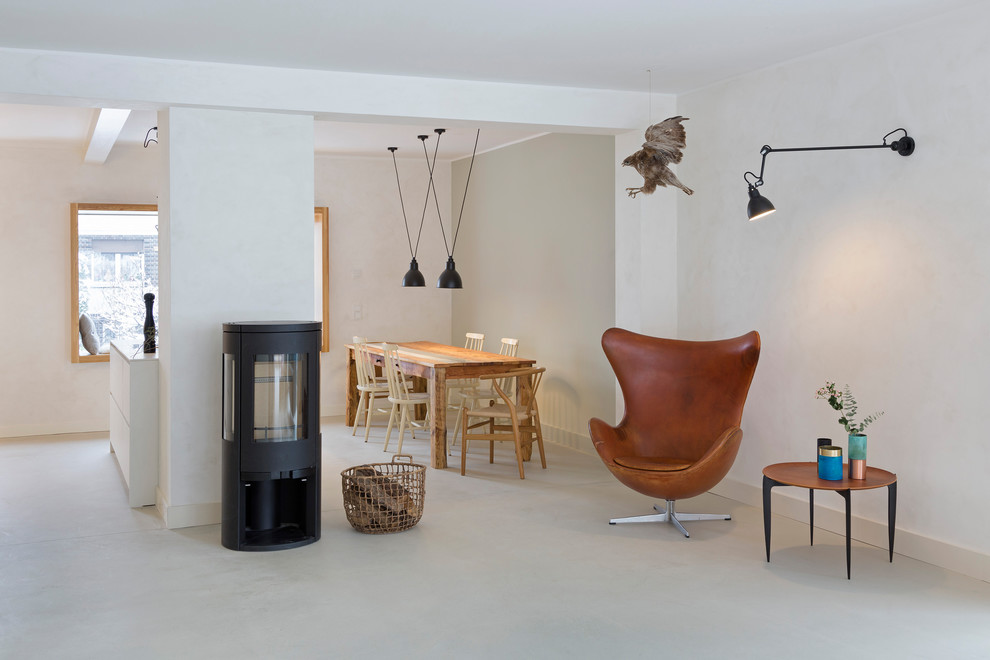 Expansive scandinavian formal open plan living room in Berlin with white walls, a wood burning stove and white floors.