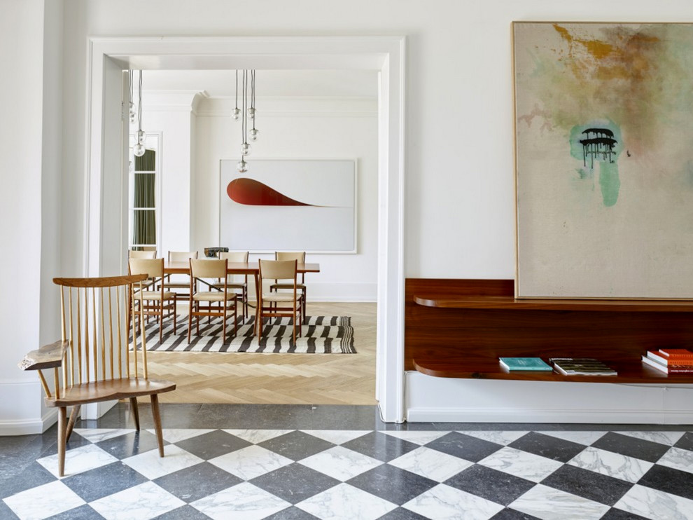 На фото: парадная, открытая гостиная комната в скандинавском стиле с белыми стенами и мраморным полом с