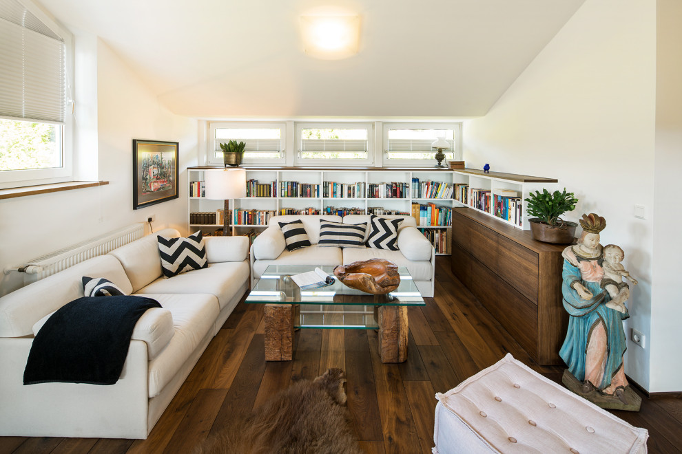 Offenes Modernes Wohnzimmer mit weißer Wandfarbe, dunklem Holzboden, braunem Boden und gewölbter Decke in Sonstige
