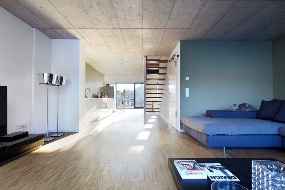 Geräumiges Industrial Wohnzimmer im Loft-Stil mit weißer Wandfarbe und hellem Holzboden in Düsseldorf