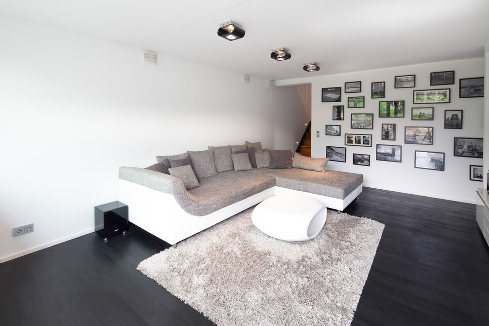 Mittelgroßes, Abgetrenntes Modernes Wohnzimmer ohne Kamin mit weißer Wandfarbe und dunklem Holzboden in Stuttgart