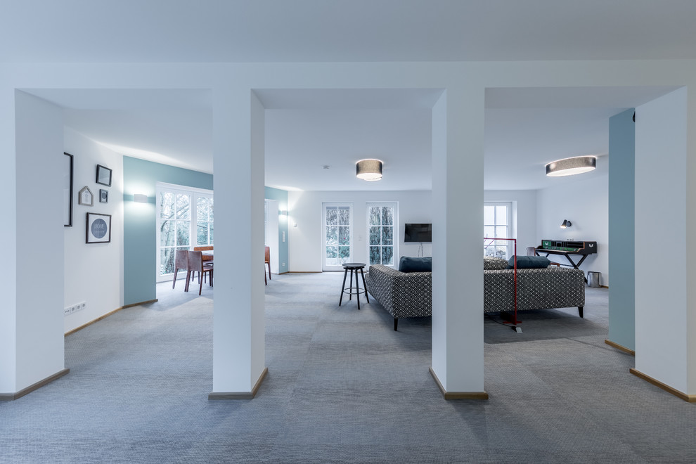 Esempio di un piccolo soggiorno minimal aperto con pavimento in vinile, TV a parete e pavimento blu