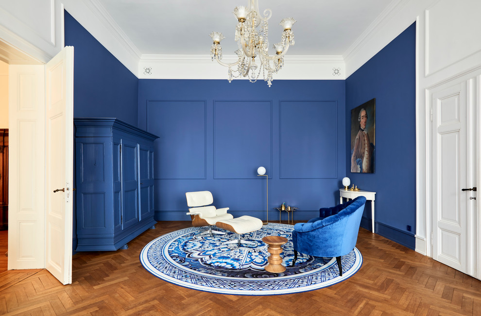 Idee per un grande soggiorno design aperto con pareti blu, pavimento in legno massello medio, TV nascosta e pavimento marrone
