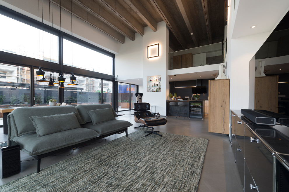 Großes, Offenes Industrial Wohnzimmer ohne Kamin mit weißer Wandfarbe, Betonboden, TV-Wand und grauem Boden in Sonstige