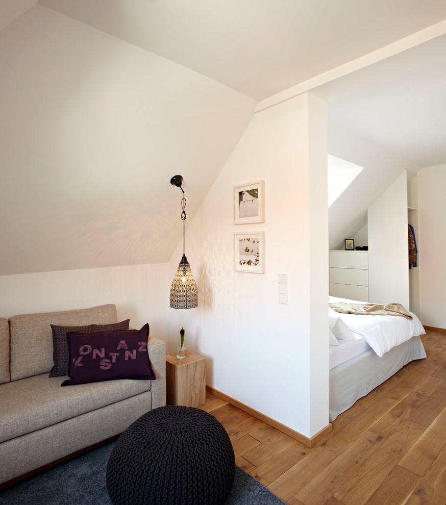 Cette photo montre un petit salon tendance avec un mur blanc, un sol en bois brun et aucune cheminée.