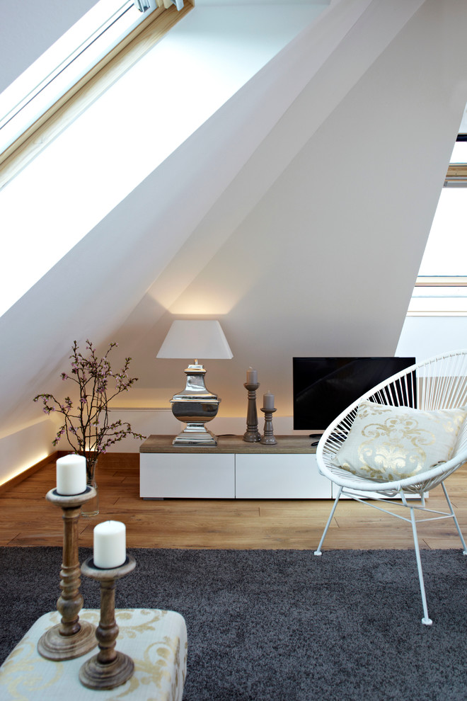 Idéer för ett litet modernt allrum, med vita väggar, mellanmörkt trägolv och en fristående TV
