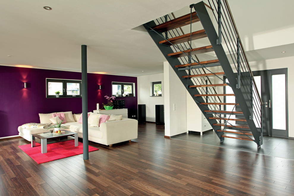 Свежая идея для дизайна: открытая гостиная комната в современном стиле с фиолетовыми стенами, темным паркетным полом и коричневым полом - отличное фото интерьера