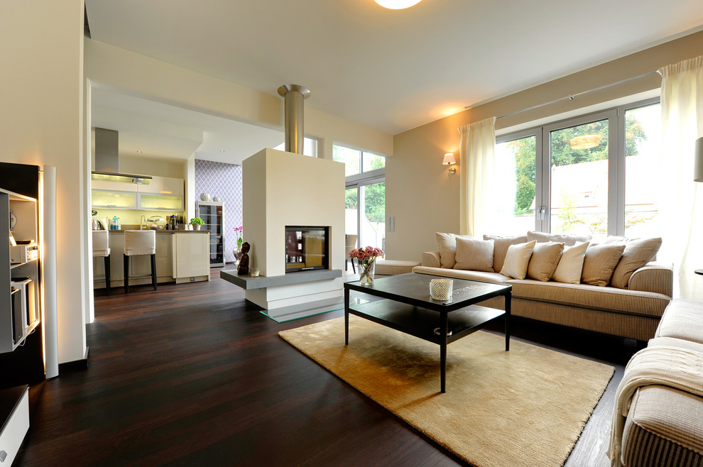 Réalisation d'un salon tradition de taille moyenne et ouvert avec une salle de réception, un mur beige, parquet foncé, une cheminée double-face, un manteau de cheminée en plâtre et un sol marron.