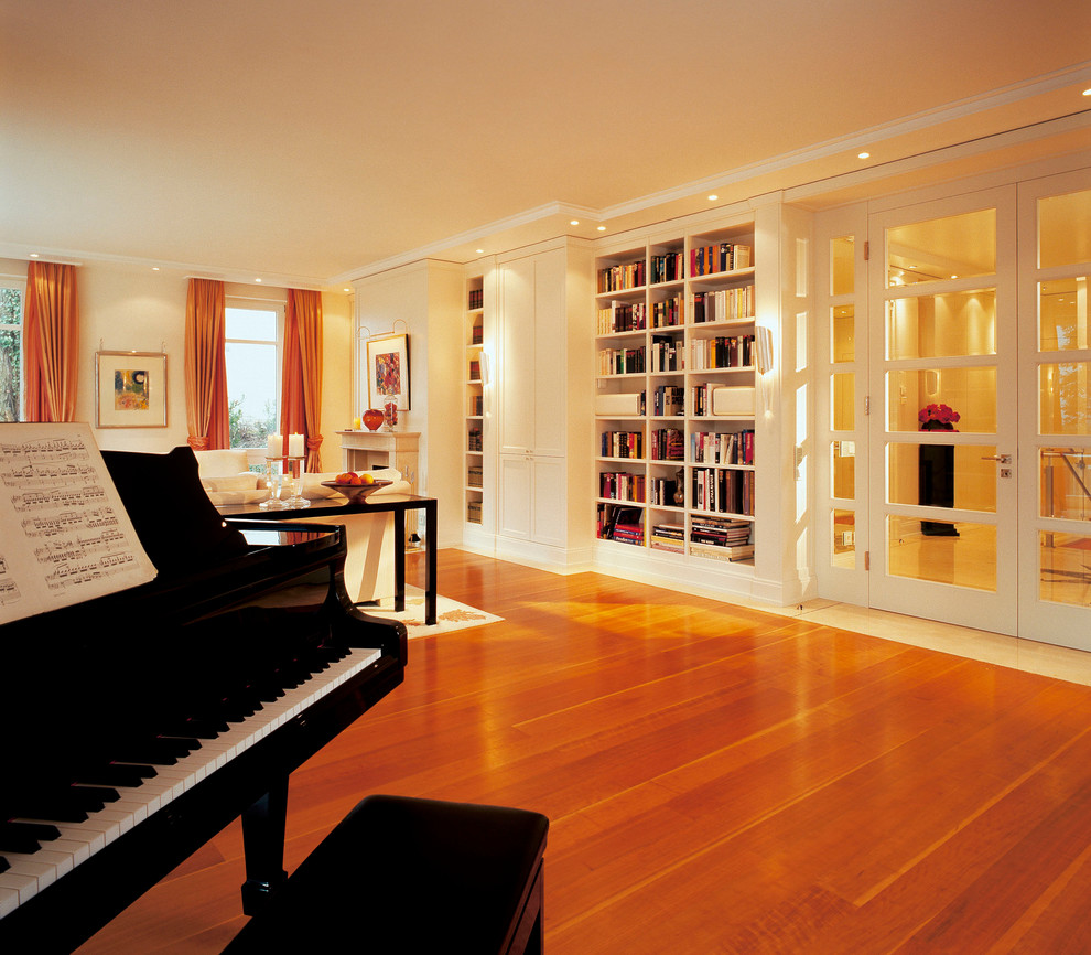Abgetrenntes Klassisches Musikzimmer mit gelber Wandfarbe, braunem Holzboden und braunem Boden in Sonstige