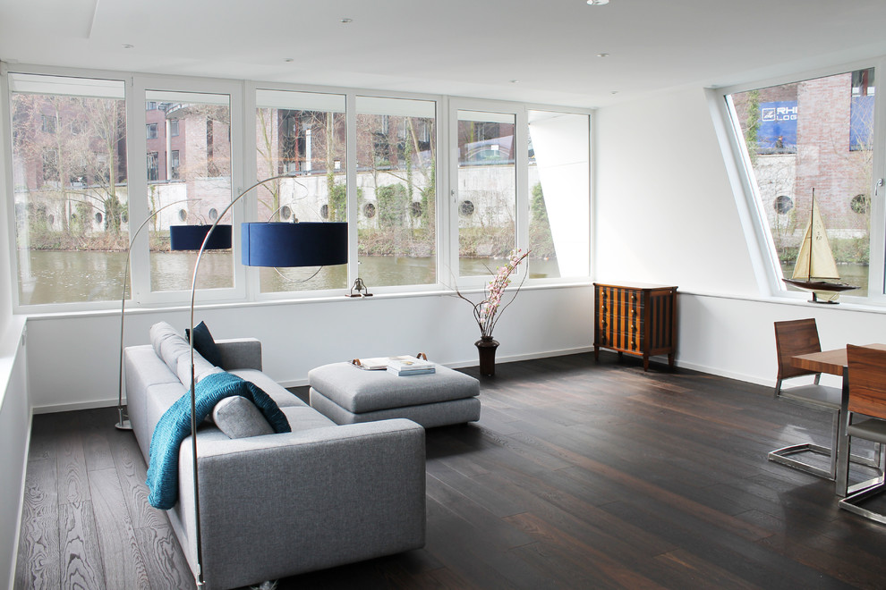 Offenes, Mittelgroßes, Fernseherloses Modernes Wohnzimmer ohne Kamin mit weißer Wandfarbe und dunklem Holzboden in Bremen