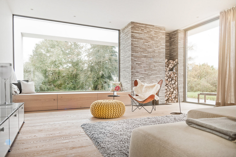 Idee per un soggiorno minimal di medie dimensioni con pareti marroni e parquet chiaro