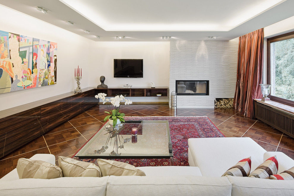 Ejemplo de sala de estar ecléctica grande con paredes blancas, suelo de madera oscura, todas las chimeneas y televisor colgado en la pared